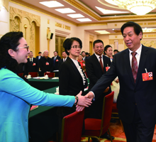 2018年，中共中央政治局常委、全国人大常委会委员长栗战书与秦和校长亲切握手